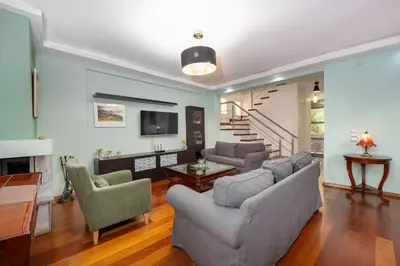 a living room with a couch and chairs and a tv at Villa Galano - Your Cozy Retreat In The Athenian Riviera in Vari