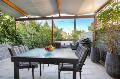a table with a bowl of fruit on a patio at Villa Galano - Your Cozy Retreat In The Athenian Riviera in Vari