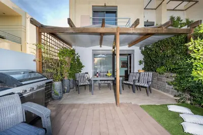 a patio with a table and chairs and a grill at Villa Galano - Your Cozy Retreat In The Athenian Riviera in Vari
