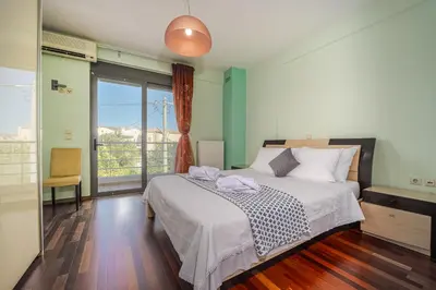 a bedroom with a bed and a large window at Villa Galano - Your Cozy Retreat In The Athenian Riviera in Vari