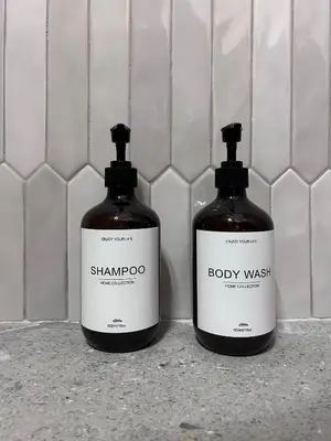 two bottles of shampoo and body wash sitting on a counter at Flisvos Beach Studio in Athens