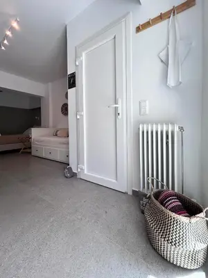 a white room with a door and a bed at Flisvos Beach Studio in Athens