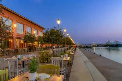 a restaurant with tables and chairs next to a river at Flisvos Beach Studio in Athens