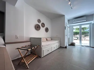 a white room with a couch and plates on the wall at Flisvos Beach Studio in Athens