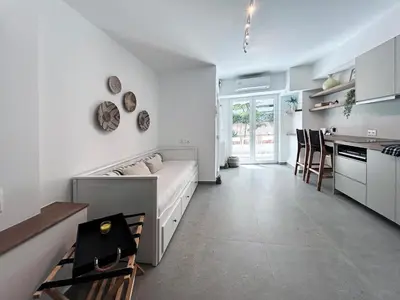 a living room and kitchen with a couch and a table at Flisvos Beach Studio in Athens