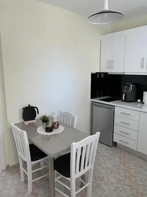 a kitchen with a table and chairs in a kitchen at Apartment near Piraeus port in Piraeus