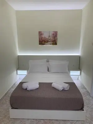 a white bed with two pillows on top of it at Apartment near Piraeus port in Piraeus