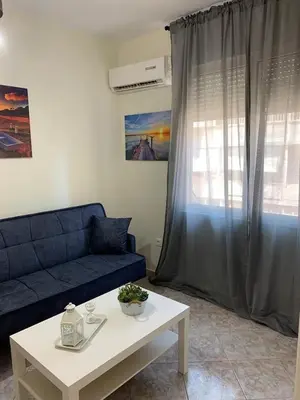 a living room with a blue couch and a table at Apartment near Piraeus port in Piraeus