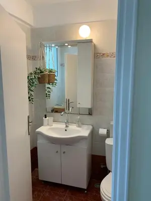 a bathroom with a sink and a toilet and a mirror at Apartment near Piraeus port in Piraeus