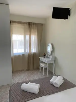 a bedroom with a bed and a table with a mirror at Apartment near Piraeus port in Piraeus