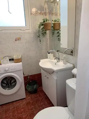 a bathroom with a washing machine and a sink at Apartment near Piraeus port in Piraeus