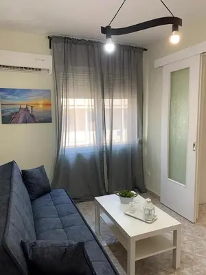 a living room with a blue couch and a table at Apartment near Piraeus port in Piraeus