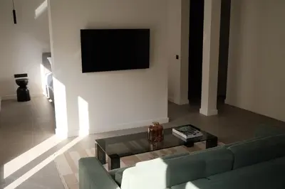 a living room with a couch and a tv on a wall at Urbanlux Boutique Apartments in Athens