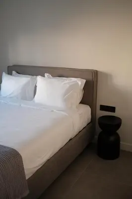 a bed with white sheets and pillows in a room at Urbanlux Boutique Apartments in Athens