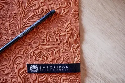 a pen sitting on top of a brown paper at Emporikon Athens Hotel in Athens