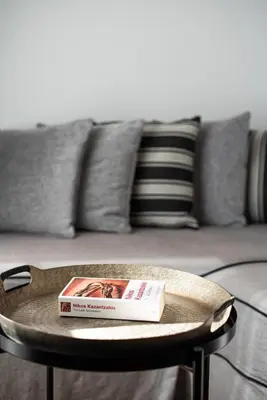 a book on a table in front of a couch at Emporikon Athens Hotel in Athens