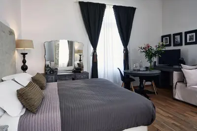 a bedroom with a bed and a table with a mirror at Emporikon Athens Hotel in Athens