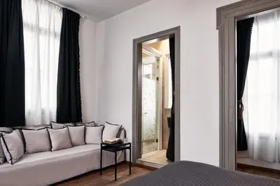 a living room with a couch and a mirror at Emporikon Athens Hotel in Athens