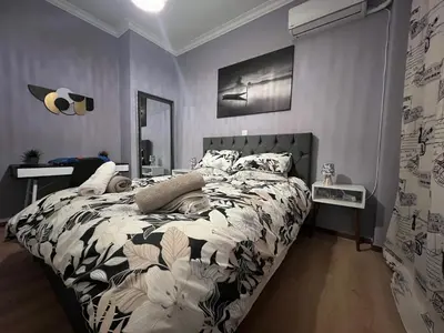 a bedroom with a bed with a black and white comforter at Kipseli NEW MoDeRN & CoZy 65TV Netflix in Athens