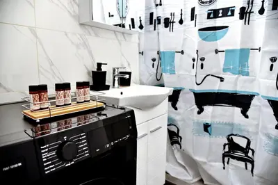a bathroom with a washing machine and a sink at Kipseli NEW MoDeRN & CoZy 65TV Netflix in Athens