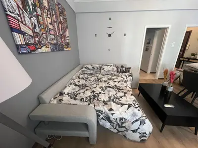 a bedroom with a bed and a table at Kipseli NEW MoDeRN & CoZy 65TV Netflix in Athens