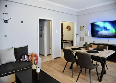 a living room with a table and a couch at Kipseli NEW MoDeRN & CoZy 65TV Netflix in Athens
