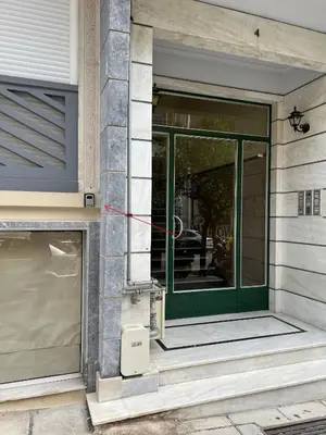 a green door on the side of a building at Kipseli NEW MoDeRN & CoZy 65TV Netflix in Athens