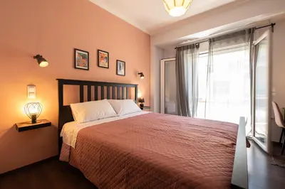 a bedroom with a large bed and a window at Vibrant apartment next to Acropolis in Athens