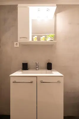 a white kitchen with a sink and a mirror at Vibrant apartment next to Acropolis in Athens