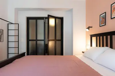 a bedroom with a large bed with a pink blanket at Vibrant apartment next to Acropolis in Athens