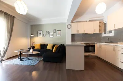 a kitchen and living room with a couch and a table at Vibrant apartment next to Acropolis in Athens