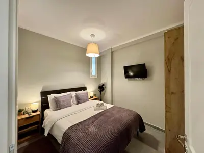 a bedroom with a bed and a tv on the wall at Comfort Downtown Marble, Koukaki Athens in Athens