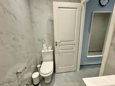 a white bathroom with a toilet and a sink at Comfort Downtown Marble, Koukaki Athens in Athens