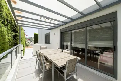 a patio with a wooden table and chairs on a balcony at Luxury Holiday Home near the Sea in Kalívia Thorikoú