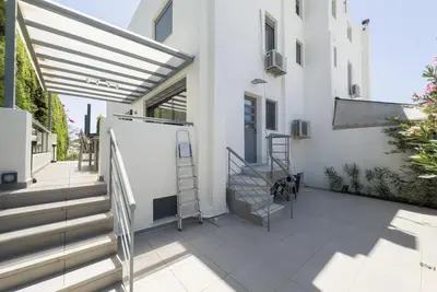 a patio with stairs and a white building at Luxury Holiday Home near the Sea in Kalívia Thorikoú