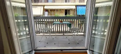 a balcony with two chairs and a table on a balcony at Urban Chic Flat Pagrati Athens in Athens