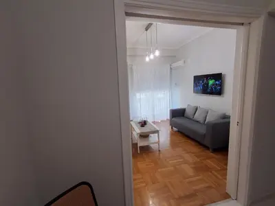 a living room with a couch and a table at Urban Chic Flat Pagrati Athens in Athens