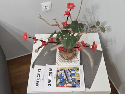 a table with a book and a potted plant at Urban Chic Flat Pagrati Athens in Athens