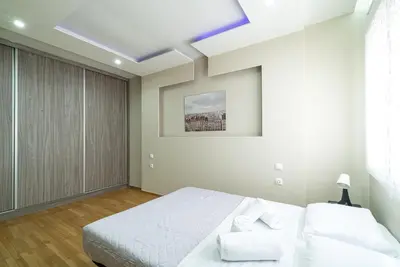 a white bedroom with a bed and a skylight at Filoxenia MG projects Alimos in Athens