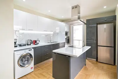 a kitchen with white cabinets and a washer and dryer at Filoxenia MG projects Alimos in Athens