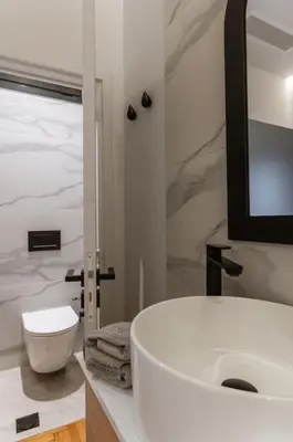 a white bathroom with a sink and a mirror at Perth Luxury Living, Athens in Athens