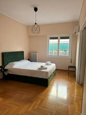 a bedroom with a large bed and a wooden floor at Acropolis Modern Apartment in Athens
