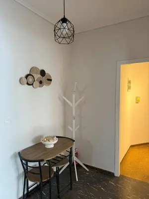 a table and chairs in a room with a yellow door at Acropolis Modern Apartment in Athens