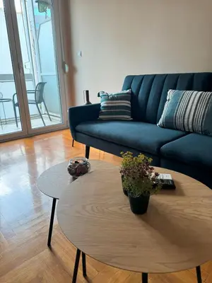 a living room with a blue couch and a coffee table at Acropolis Modern Apartment in Athens