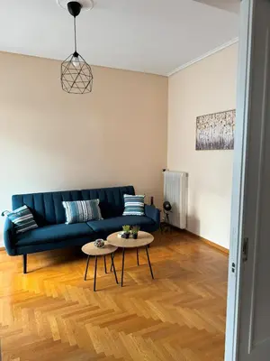 a living room with a blue couch and a table at Acropolis Modern Apartment in Athens