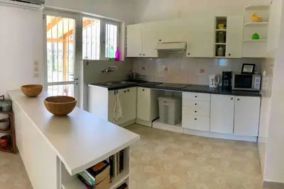 a large kitchen with white cabinets and a counter top at Fysis Panorama spectacular view in Porto Rafti