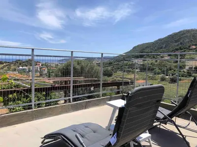 a pair of chairs sitting on top of a balcony at Fysis Panorama spectacular view in Porto Rafti