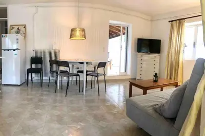 a living room with a couch and a table and chairs at Fysis Panorama spectacular view in Porto Rafti