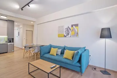 a living room with a blue couch and a table at Athenian Escape 2BR, 2BA, Stylish Fully Reno Apt in Athens