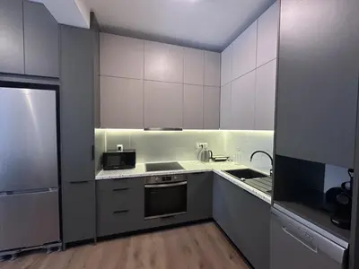 a kitchen with white cabinets and a sink and a stove at Athenian Escape 2BR, 2BA, Stylish Fully Reno Apt in Athens